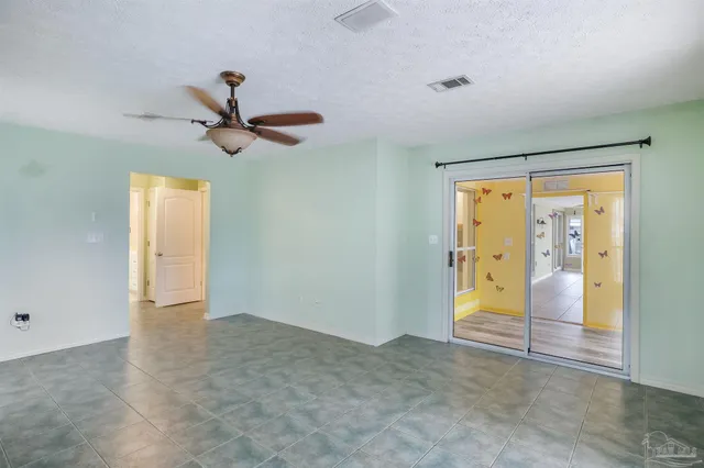a view of a room with a ceiling fan and window