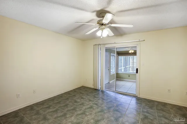 an empty room and chandelier fan
