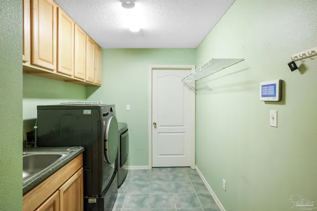 a bathroom with a granite countertop sink and washing machine