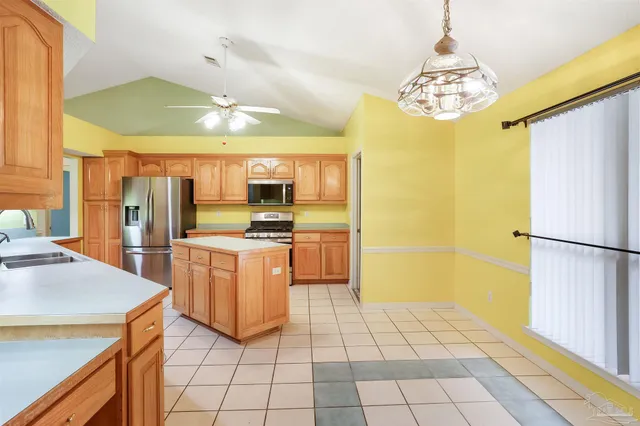 a kitchen with stainless steel appliances a refrigerator and a stove top oven