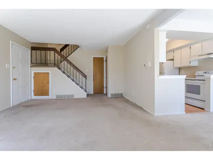 a view of an empty room with a kitchen