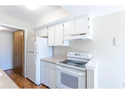 a kitchen with stainless steel appliances white cabinets and a refrigerator