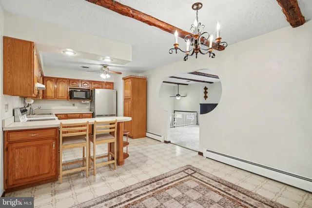 a kitchen with stainless steel appliances a table and chairs