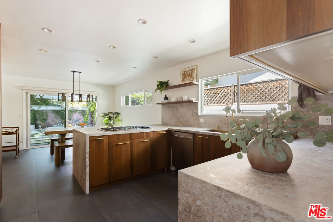 5719 Rhodes Avenue Valley Village, CA 91607 - Photo 18 of 55 a kitchen with stainless steel appliances granite countertop a sink dishwasher a stove and a dining table with wooden floor