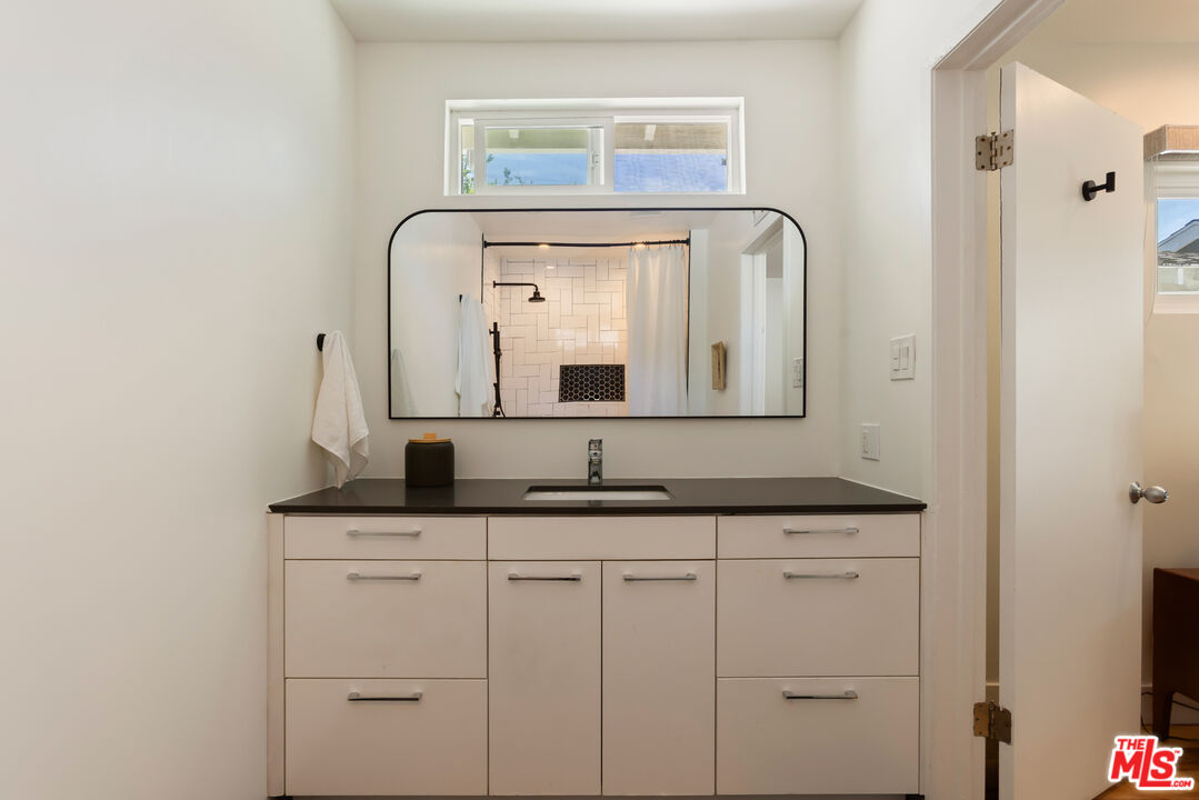 5719 Rhodes Avenue Valley Village, CA 91607 - Photo 37 of 55 a bathroom with a granite countertop sink and a mirror