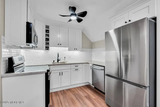 a metallic refrigerator freezer sitting in a kitchen