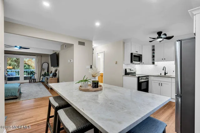 a kitchen with stainless steel appliances granite countertop a stove refrigerator a sink dishwasher with a dining table and chairs