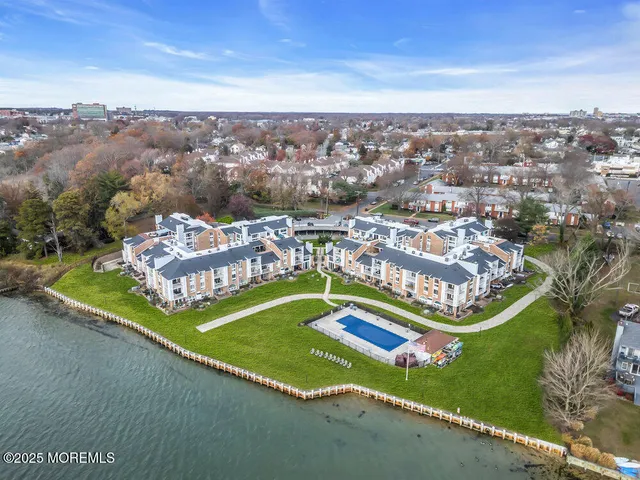 an aerial view of residential houses with outdoor space and river