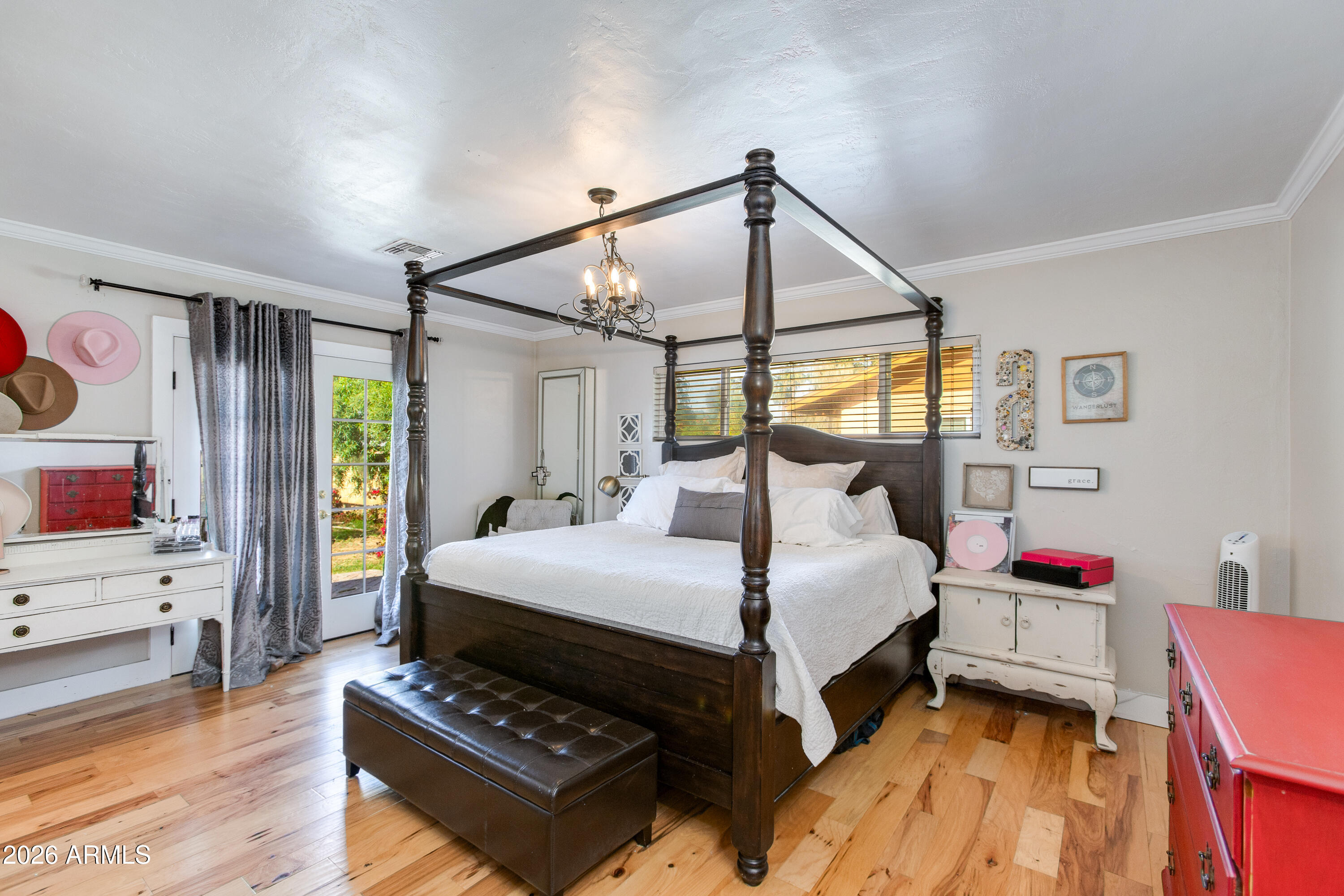 7830 North 7th Avenue Phoenix, AZ 85021 - Photo 16 of 43 a bedroom with a bed a chandelier and a flat tv screen on the dresser