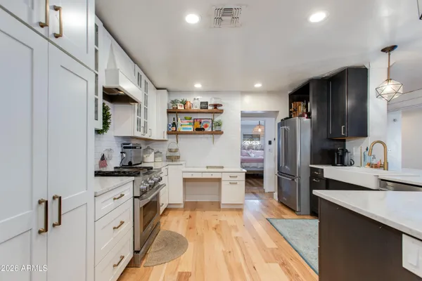 a kitchen with stainless steel appliances white cabinets and a stove top oven