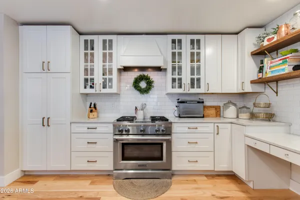 a kitchen with stainless steel appliances granite countertop a sink dishwasher and a stove with wooden floor