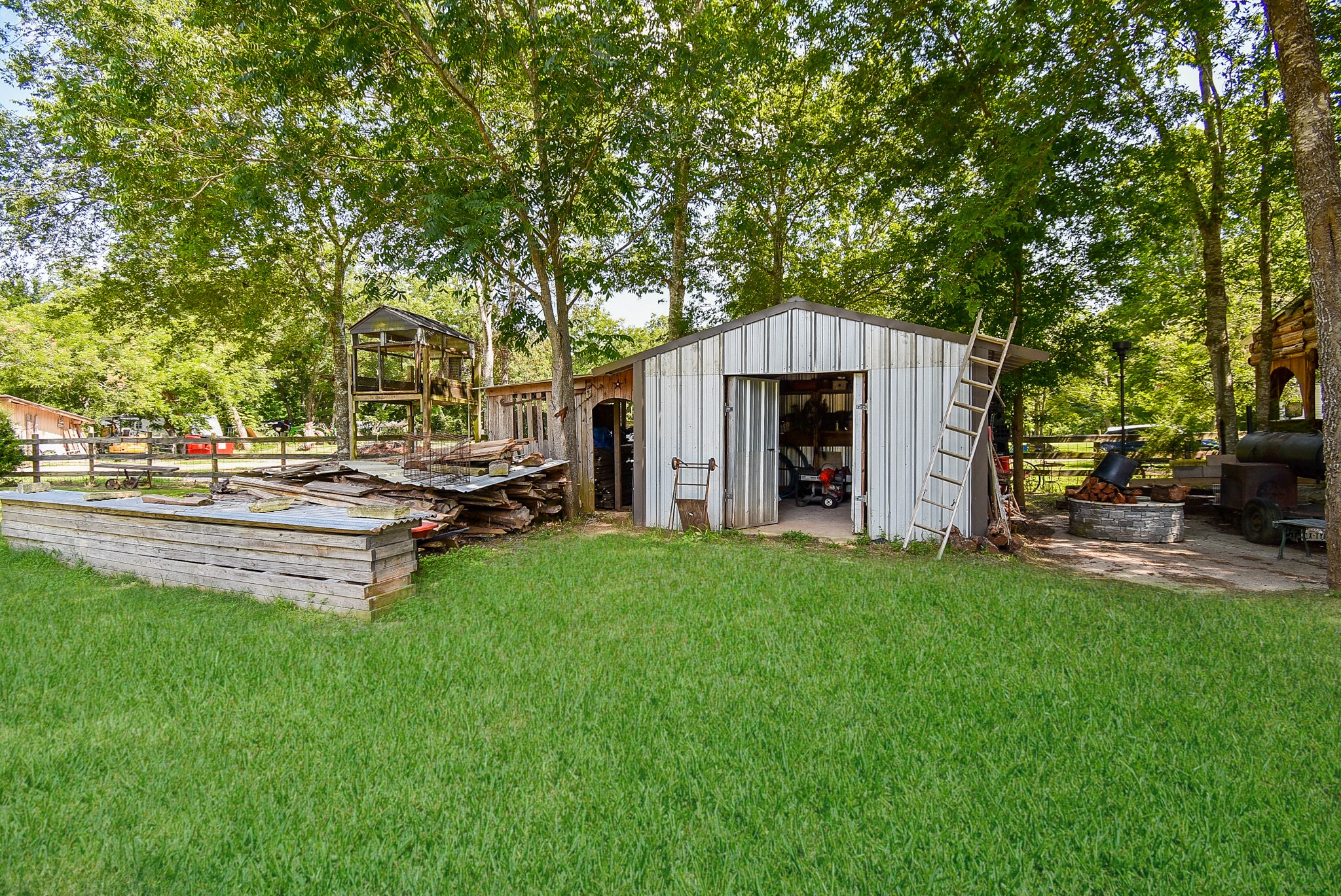 39551 Donigan Road Brookshire, TX 77423 - Photo 17 of 37 View of grassy yard featuring an outbuilding, a patio, and view of scattered trees