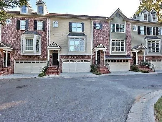 front view of a brick house with a yard