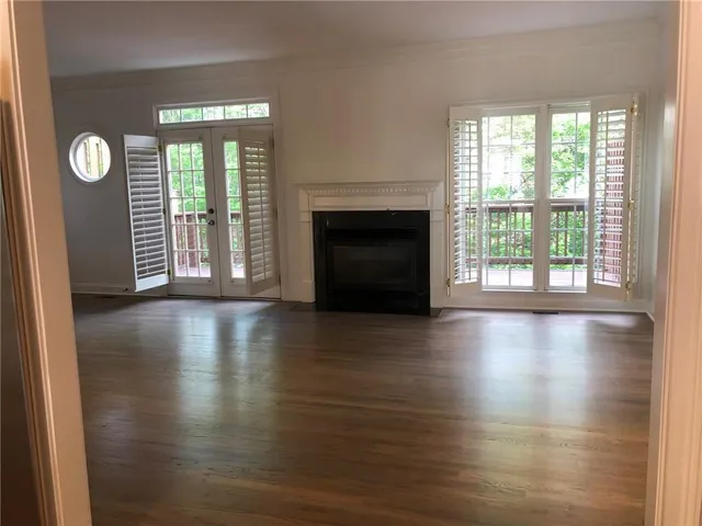 a view of a livingroom with wooden floor and a fireplace