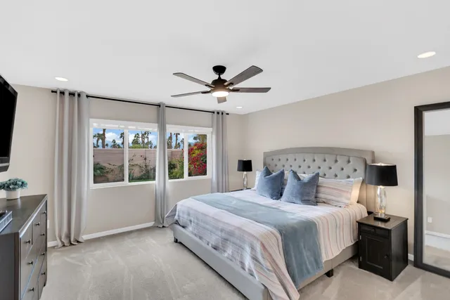 a bedroom with a large bed and a flat tv screen on dresser
