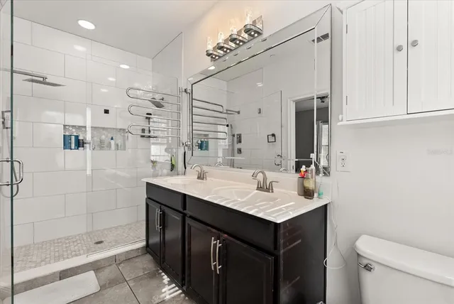 a bathroom with a sink toilet double vanity and shower