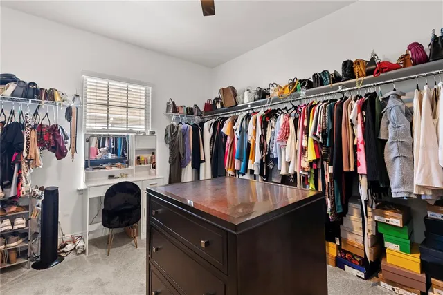 a view of walk in closet with clothes and shoes