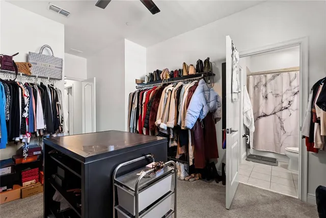 a view of walk in closet with clothes and shoes