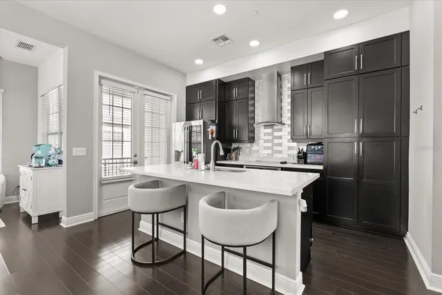 a kitchen with stainless steel appliances granite countertop a sink refrigerator and wooden floor