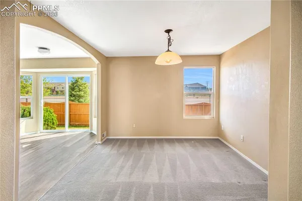 a living room with stainless steel appliances furniture a large window and wooden floors