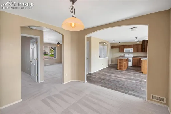 a kitchen with a wooden floor and entrance