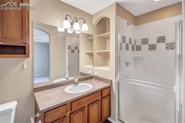 a bathroom with a granite countertop sink toilet a mirror and bathtub