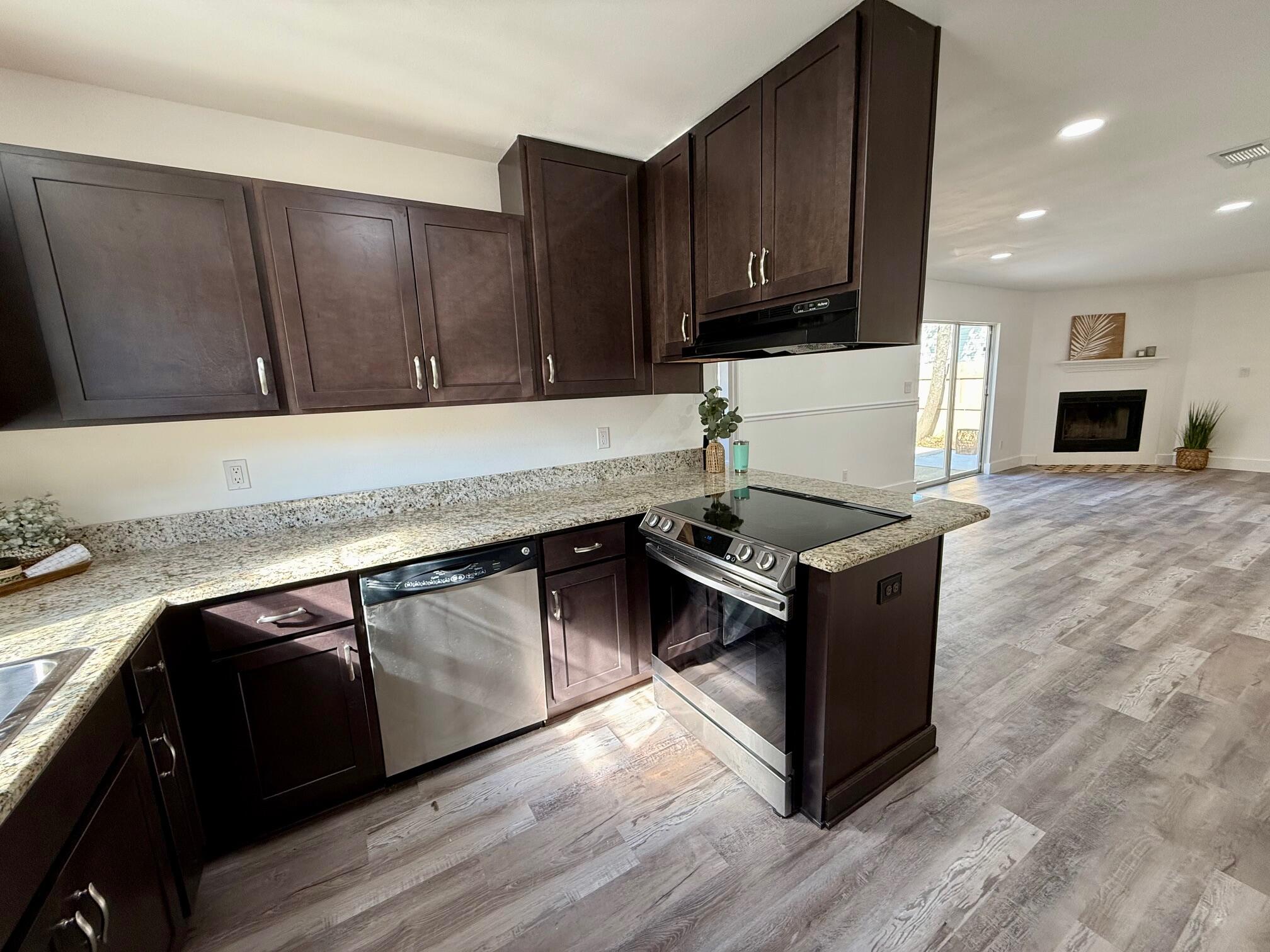 44 Ruby Circle Mary Esther, FL 32569 - Photo 8 of 34 a kitchen with granite countertop a stove and a wooden cabinets