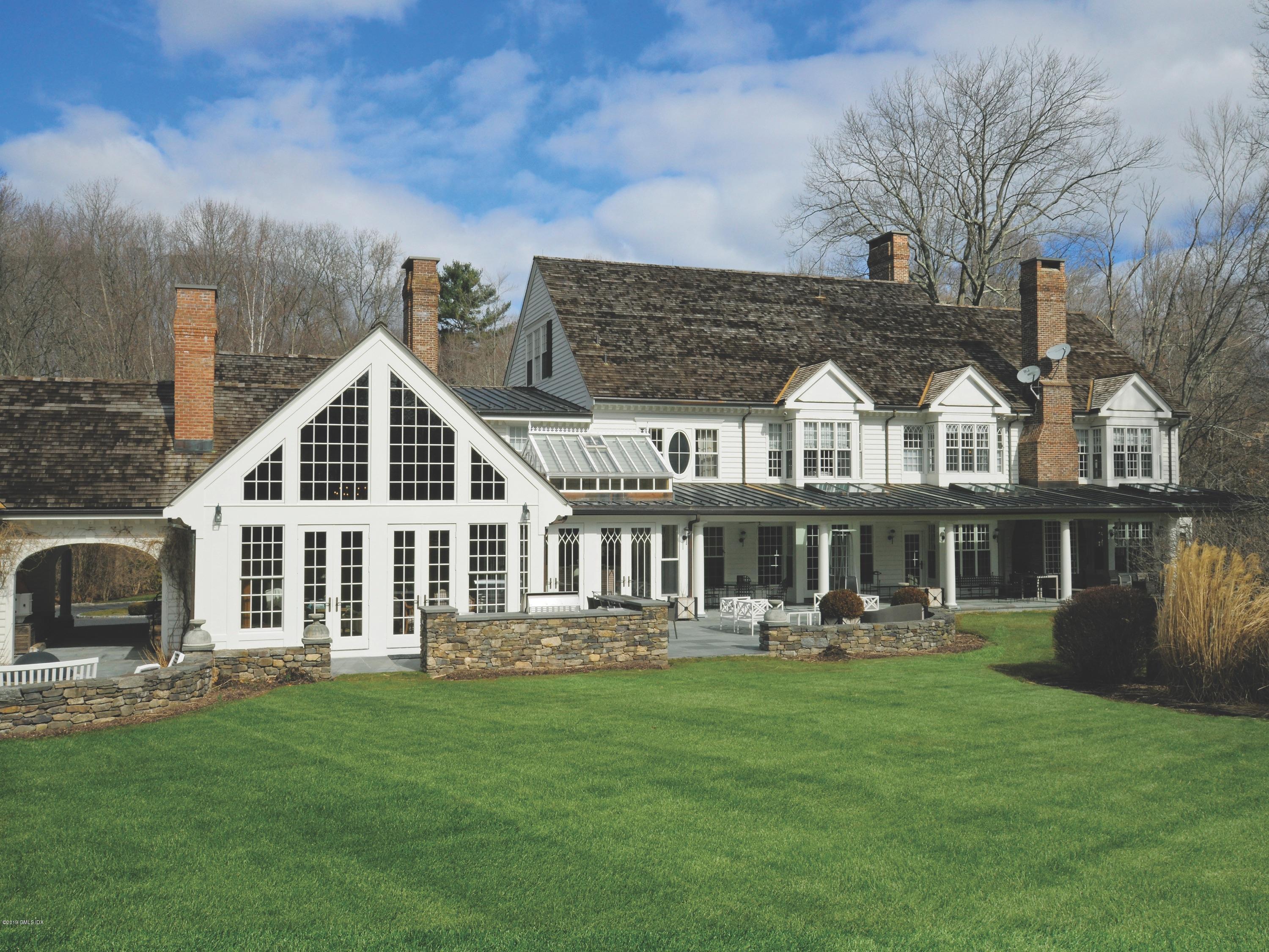 74 Upper Cross Road Greenwich, CT 06831 - Photo 14 of 21 a front view of a house with a yard table and chairs