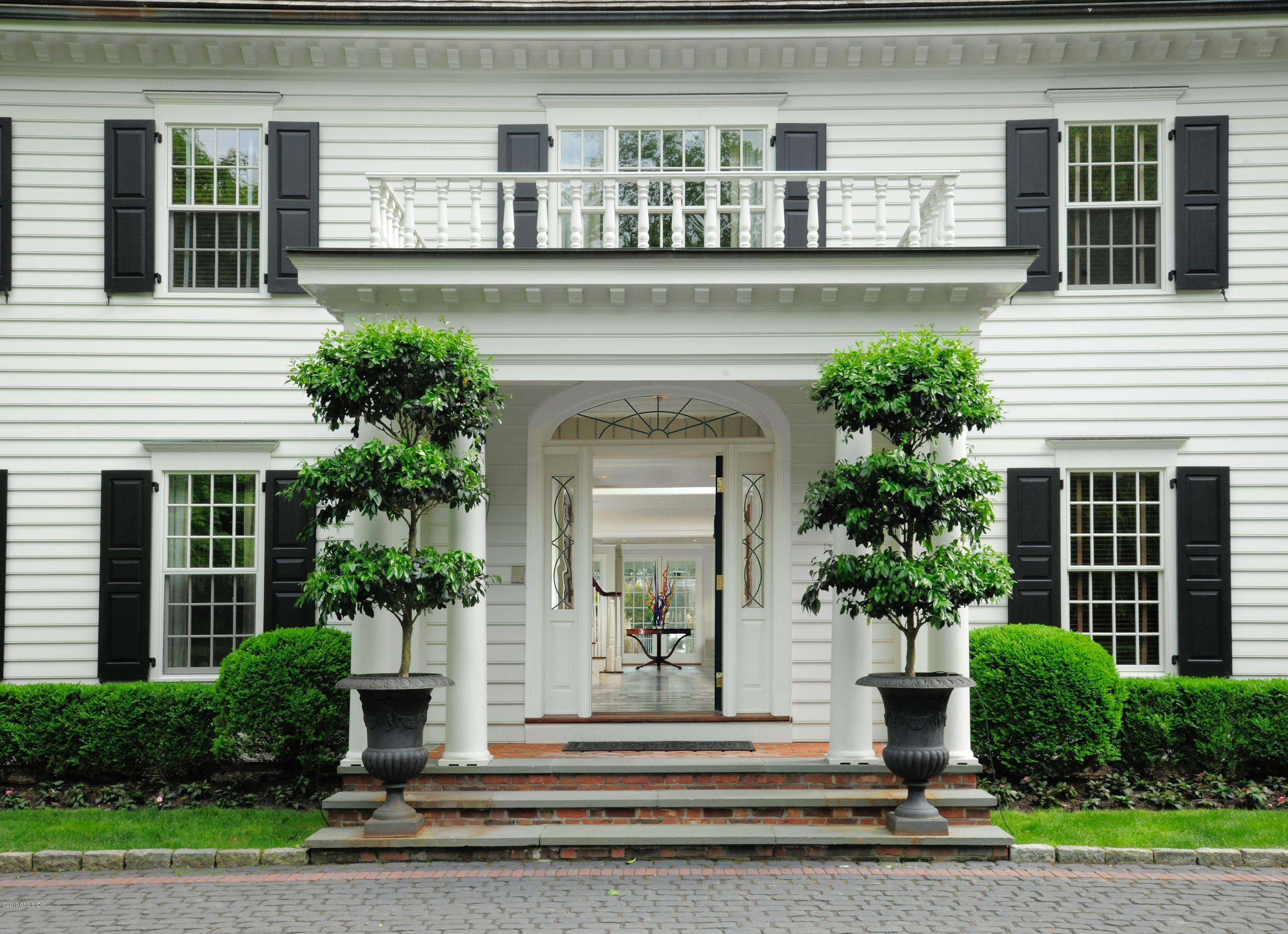 74 Upper Cross Road Greenwich, CT 06831 - Photo 2 of 21 a front view of a house with a garden