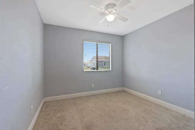 an empty room with a window and a fan