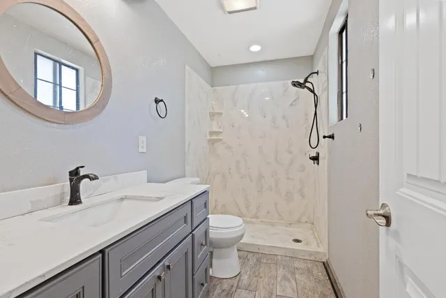 a bathroom with a sink a toilet and shower