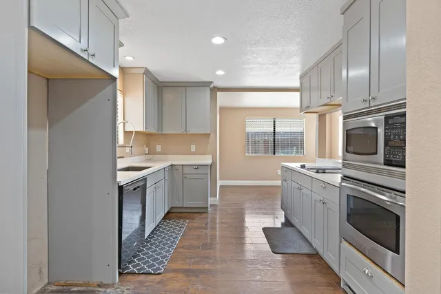 a kitchen with stainless steel appliances granite countertop a stove top oven a sink and dishwasher