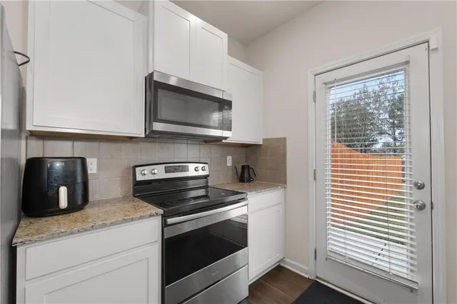 a kitchen with a microwave stove top oven and sink