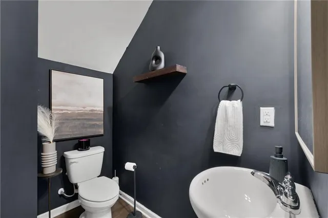 a bathroom with a toilet a sink and mirror