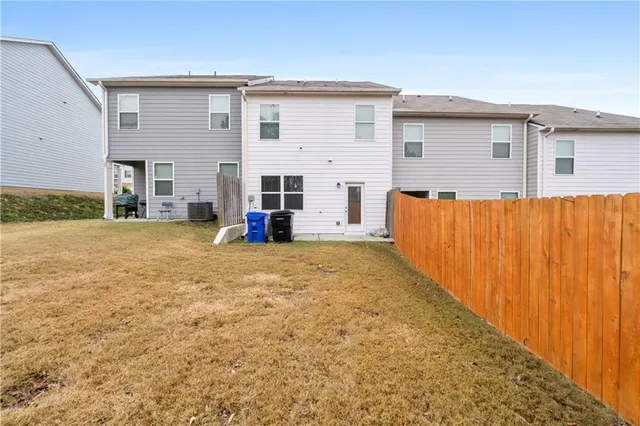 a view of a house with backyard and wooden fence