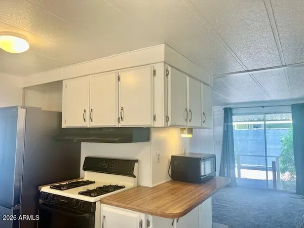 a kitchen with granite countertop a stove a refrigerator and a sink