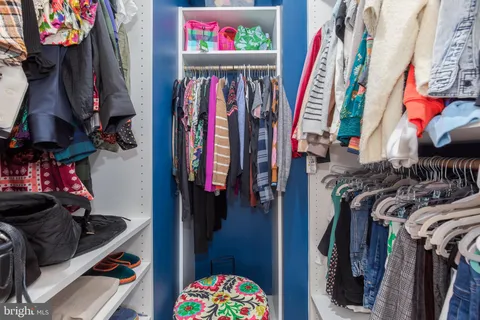 a view of walk in closet with clothes and shoes