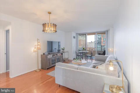 a living room with furniture a chandelier and a window