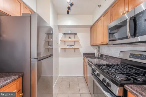 a kitchen with stainless steel appliances granite countertop a stove and a refrigerator