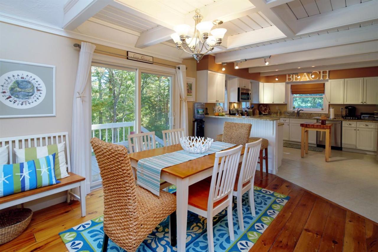 a dining room with wooden floor a chandelier a wooden table and chairs