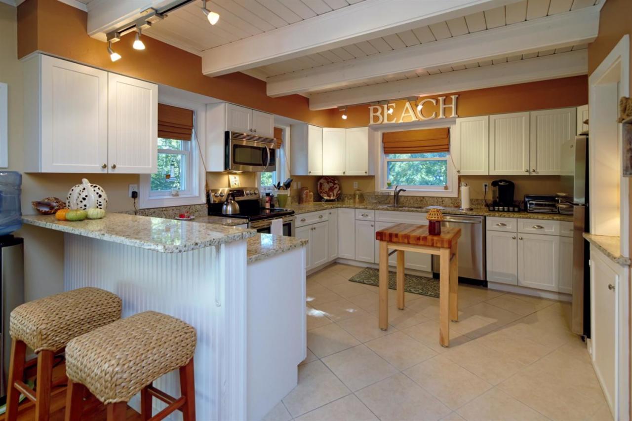 71 Captain Carltons Road Cotuit, MA 02635 - Photo 7 of 21 a kitchen with a cabinets a sink and chairs