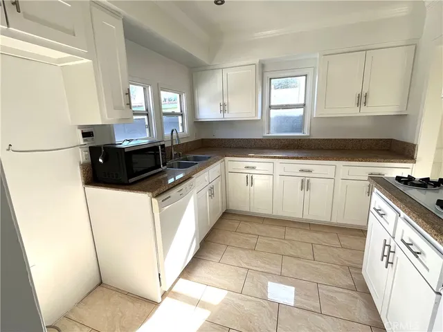 a kitchen with cabinets a sink and appliances