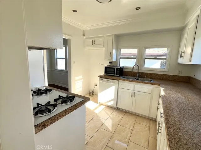 a kitchen with granite countertop a stove and a sink