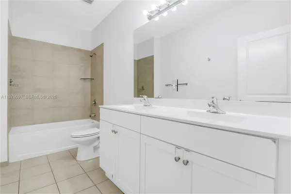 a kitchen with white cabinets and refrigerator