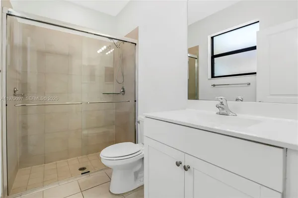 a kitchen with granite countertop a refrigerator and a stove top oven
