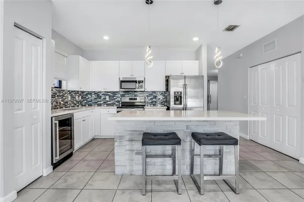 a kitchen with stainless steel appliances a stove a sink a refrigerator and cabinets