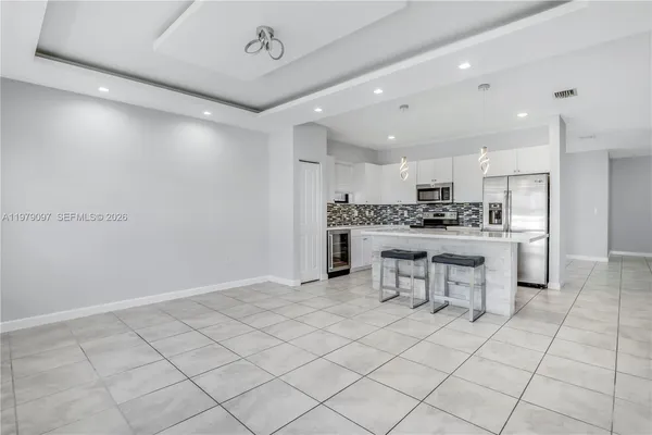 a kitchen with kitchen island granite countertop a stove a sink and a refrigerator