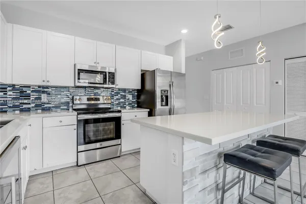 a kitchen with stainless steel appliances granite countertop a stove and a microwave