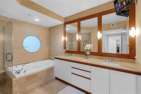 a bathroom with a granite countertop sink mirror and bathtub