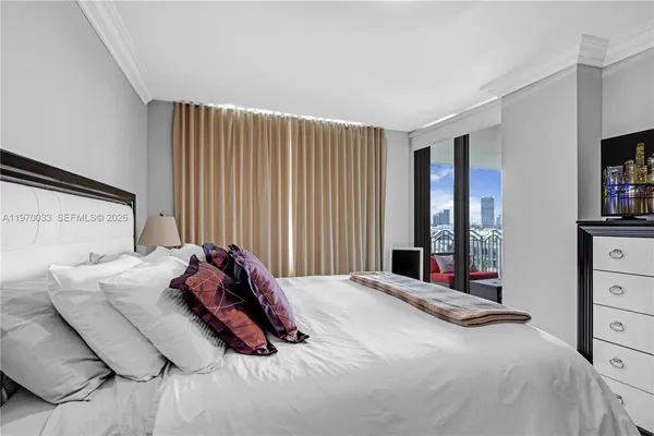 a bedroom with a bed and a flat tv screen in it